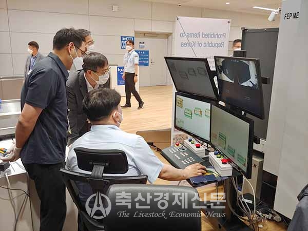 농림축산식품부와 농림축산검역본부 직원들이 인천공항에 새롭게 설치한 농축산물 검역 전용 엑스레의 기능을 살펴보고 있다.