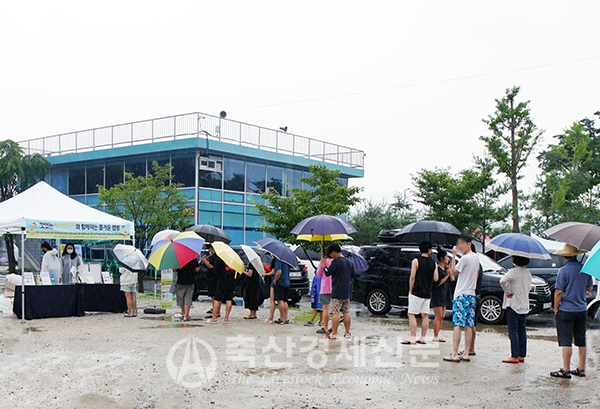 한 캠핑장 이용객들이 오리고기 홍보 행사에 참여키 위해 길게 줄을 서 있다.