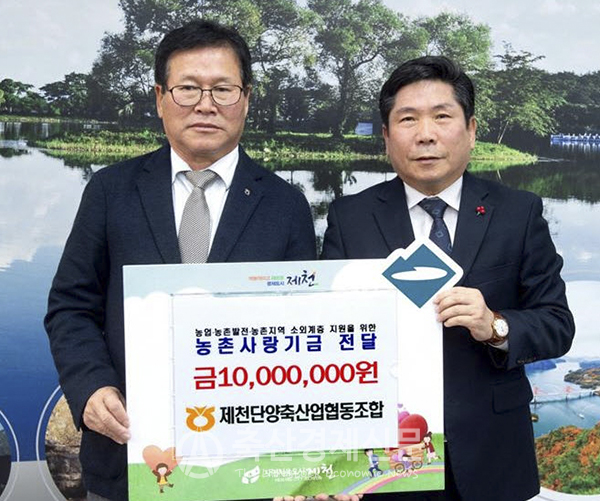 유도식 제천단양축협 조합장(왼쪽)이 김창규 제천시장에게 성금을 전달하고 있다.
